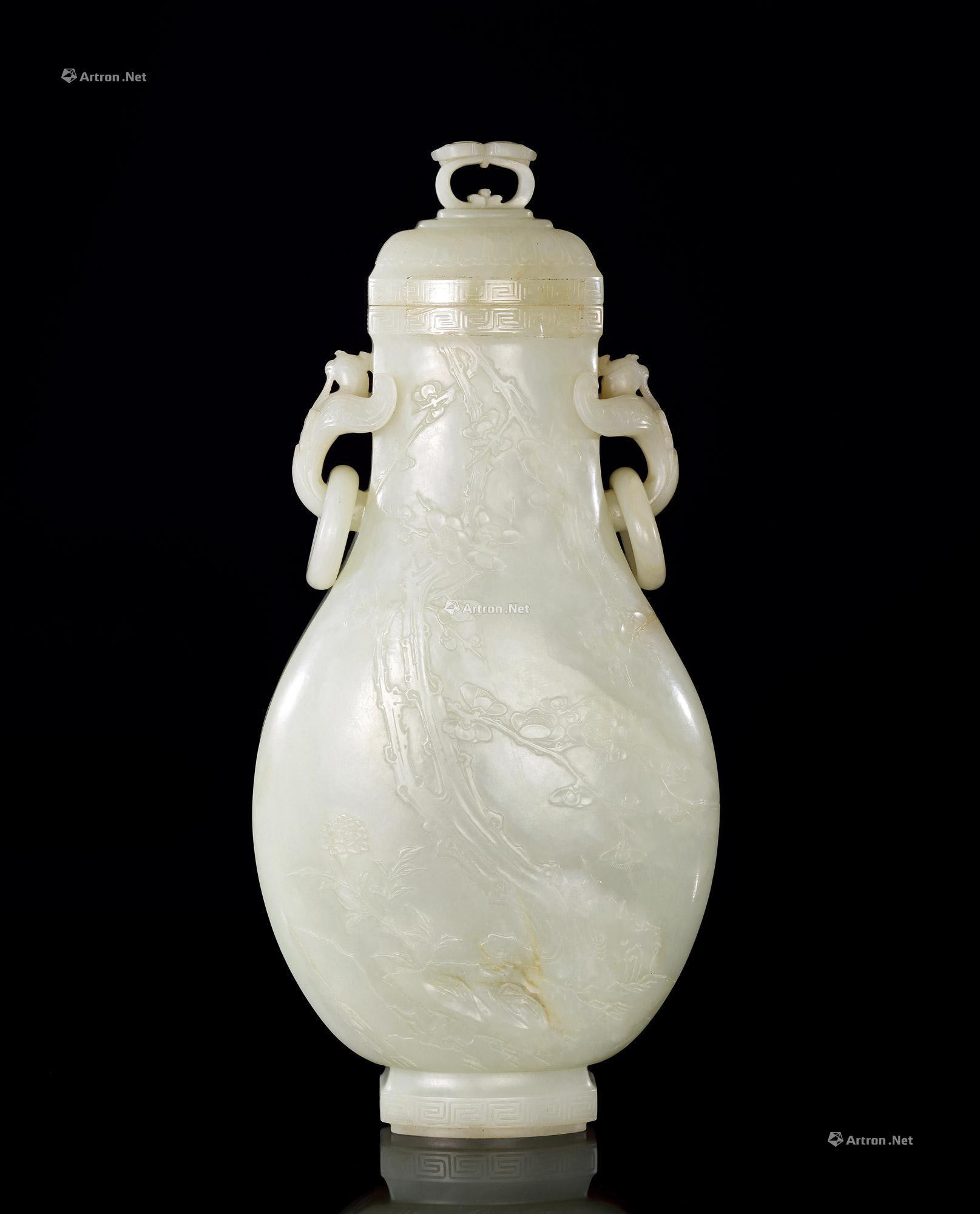 A WHITE JADE PRUNUS PATTERNED VASE WITH COVER