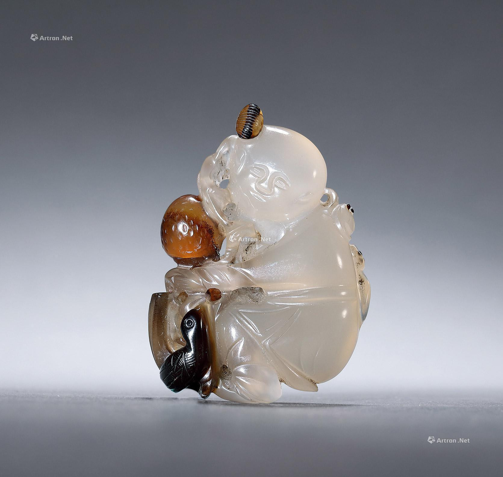 A CARVED AGATE PENDANT WITH DESIGN OF CHILD PLAYING