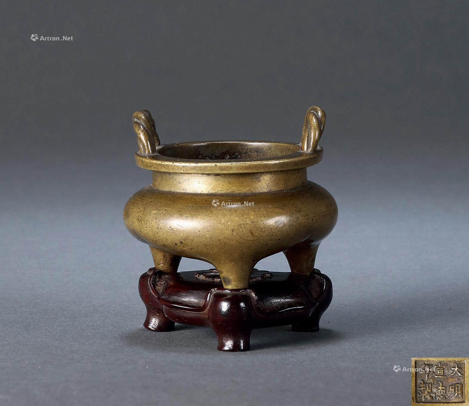 A BRONZE TRIPOD CENSER WITH STRING-LIKE EARRS