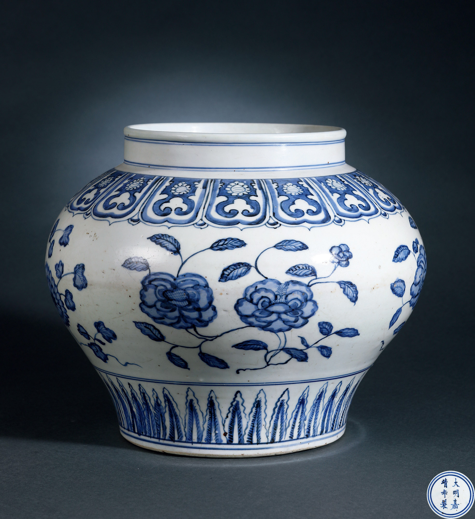 A BLUE AND WHITE JAR WITH FLOWERS DESIGN