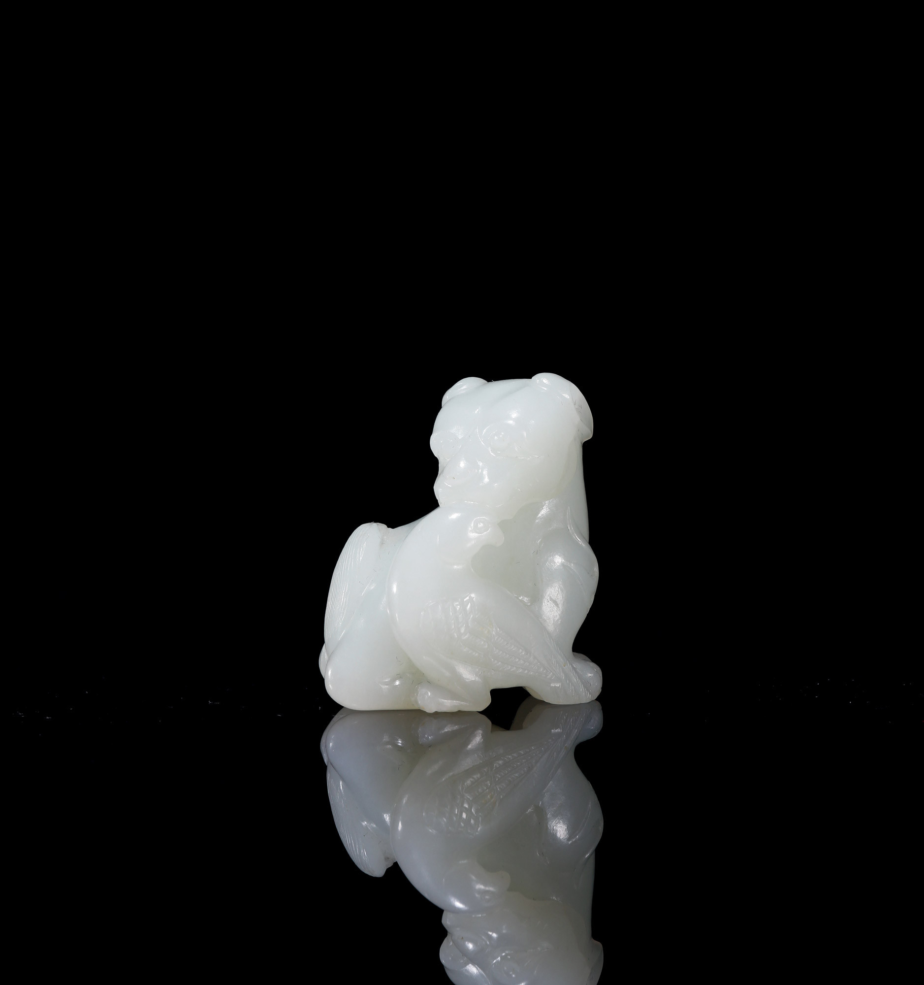 A CARVED WHITE JADE ‘EAGLE AND BEER’