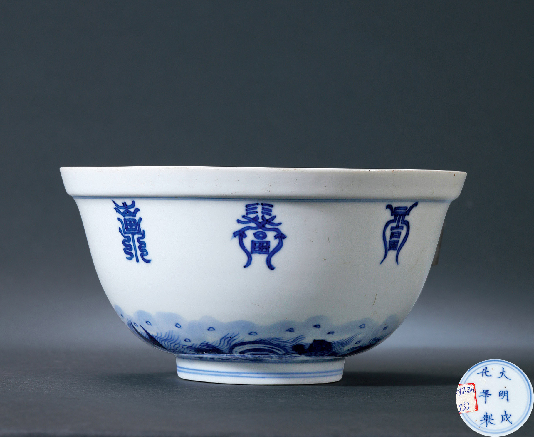 A BLUE AND WHITE BOWL WITH DRAGON DESIGN