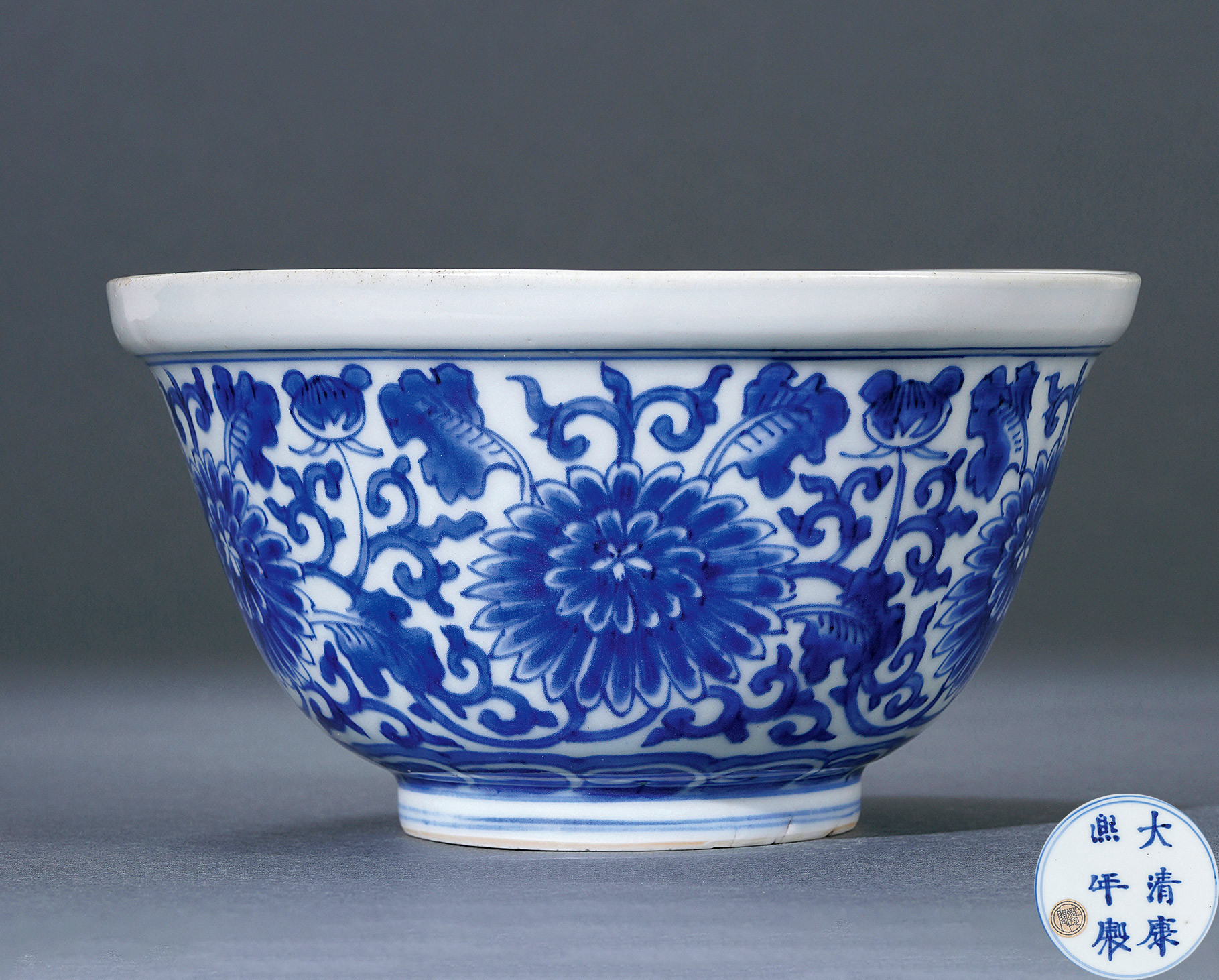 A BLUE AND WHITE BOWL WITH FLOWER DESIGN