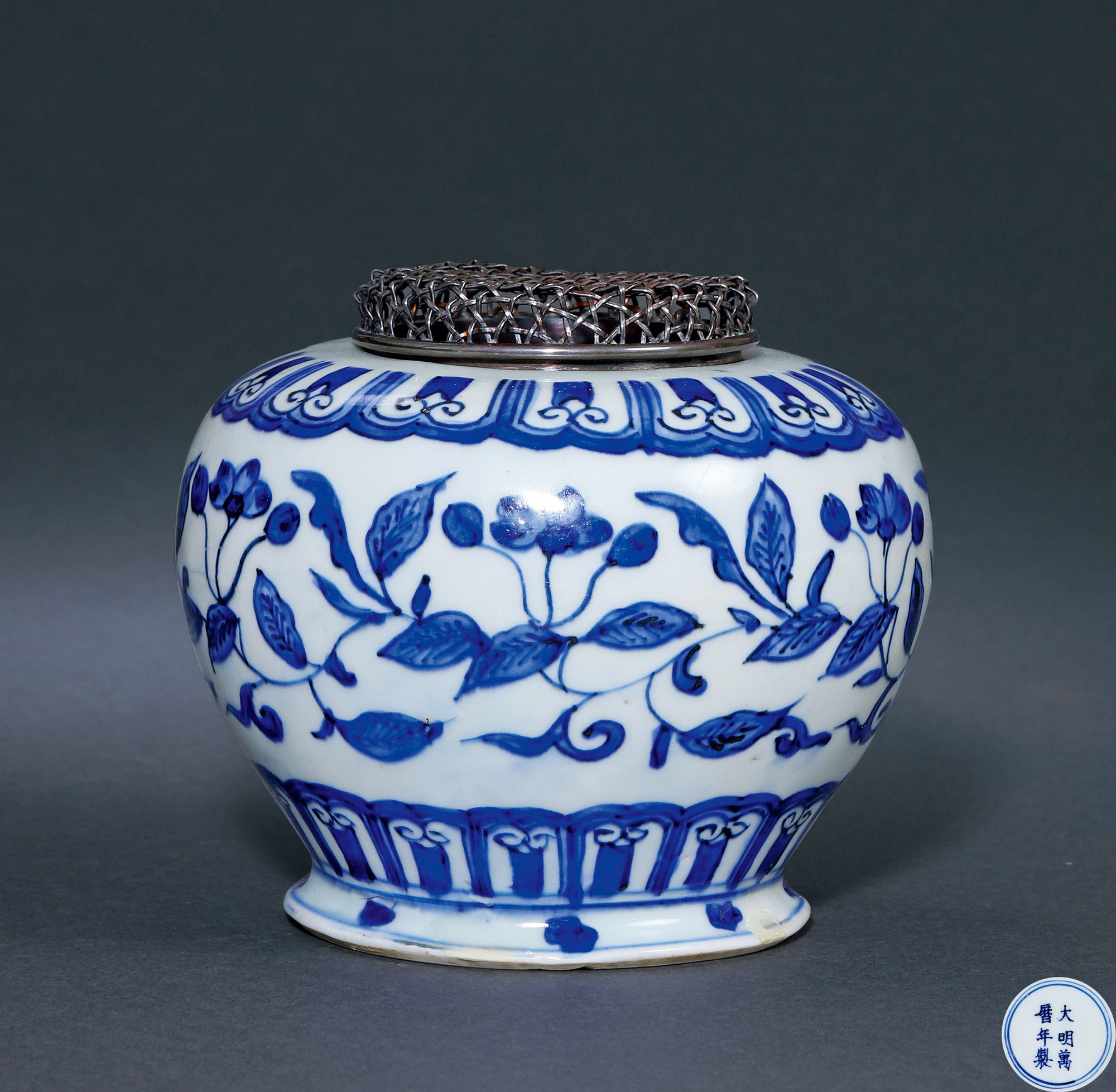 A BLUE AND WHITE JAR WITH FLOWER DESIGN