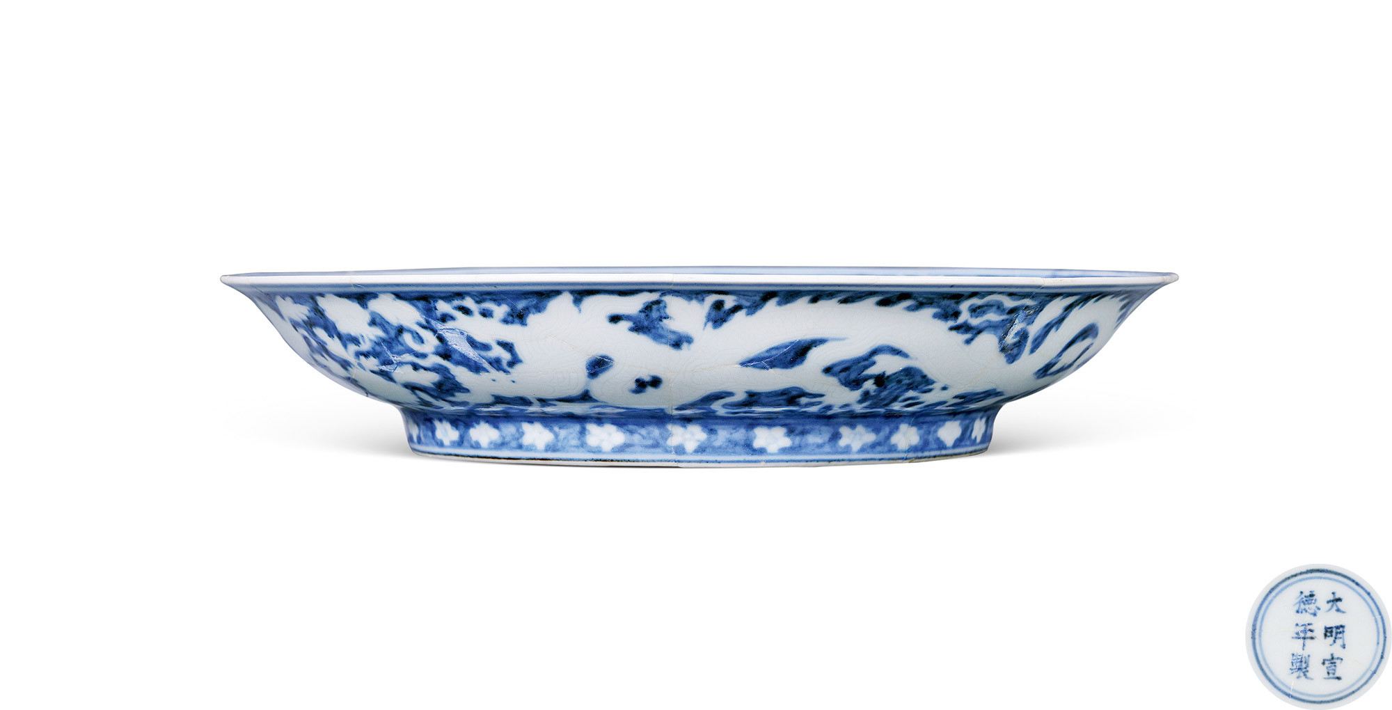 A BLUE AND WHITE PLATE WITH CARVING DRAGON DESIGN