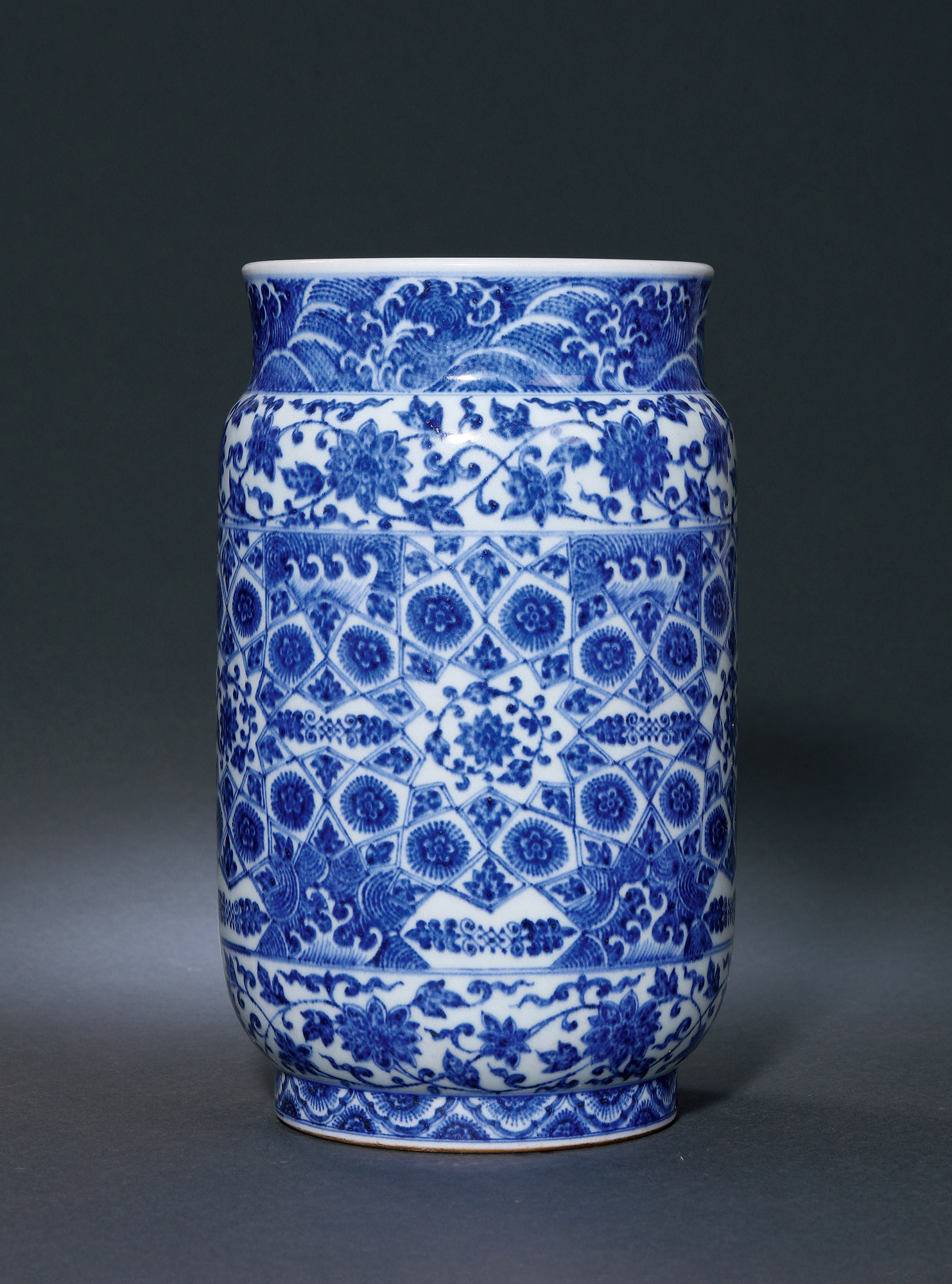 A BLUE AND WHITE URN WITH FLOWER AND WAVE DESIGN
