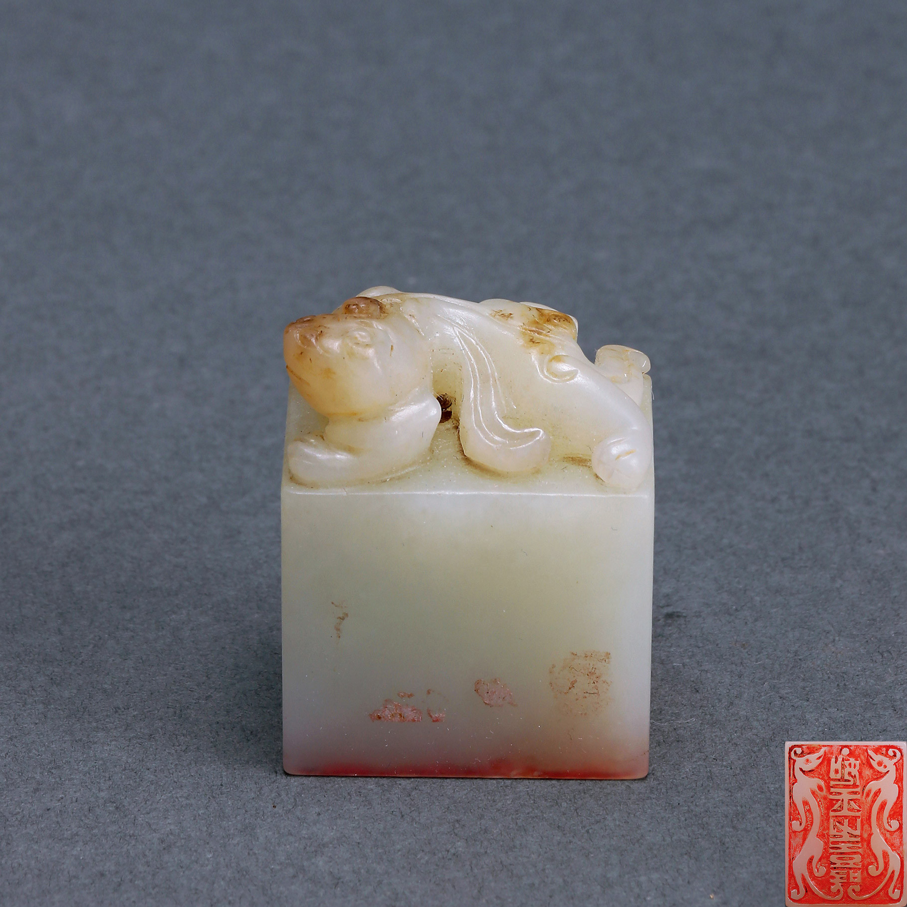 A GREEN-WHITE JADE SEAL WITH CARVED CHI-DRAGON KNOB