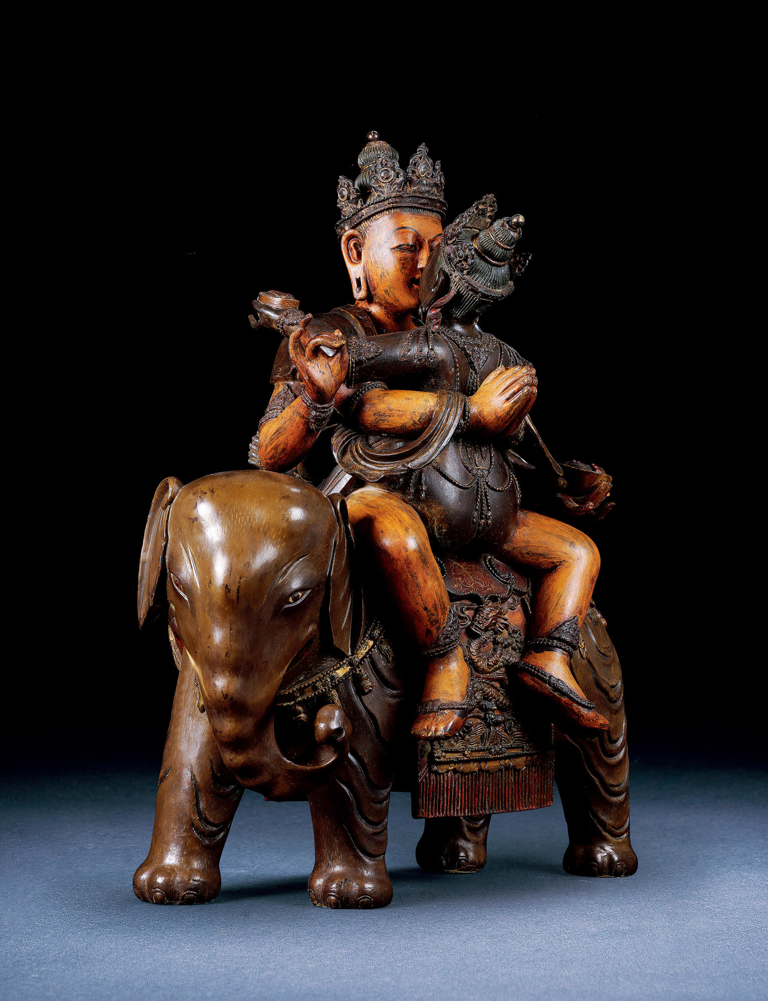 A GILT-LACQUERED SEATED SCULPTURE OF BUDDHA RIDING AN ELEPHANT