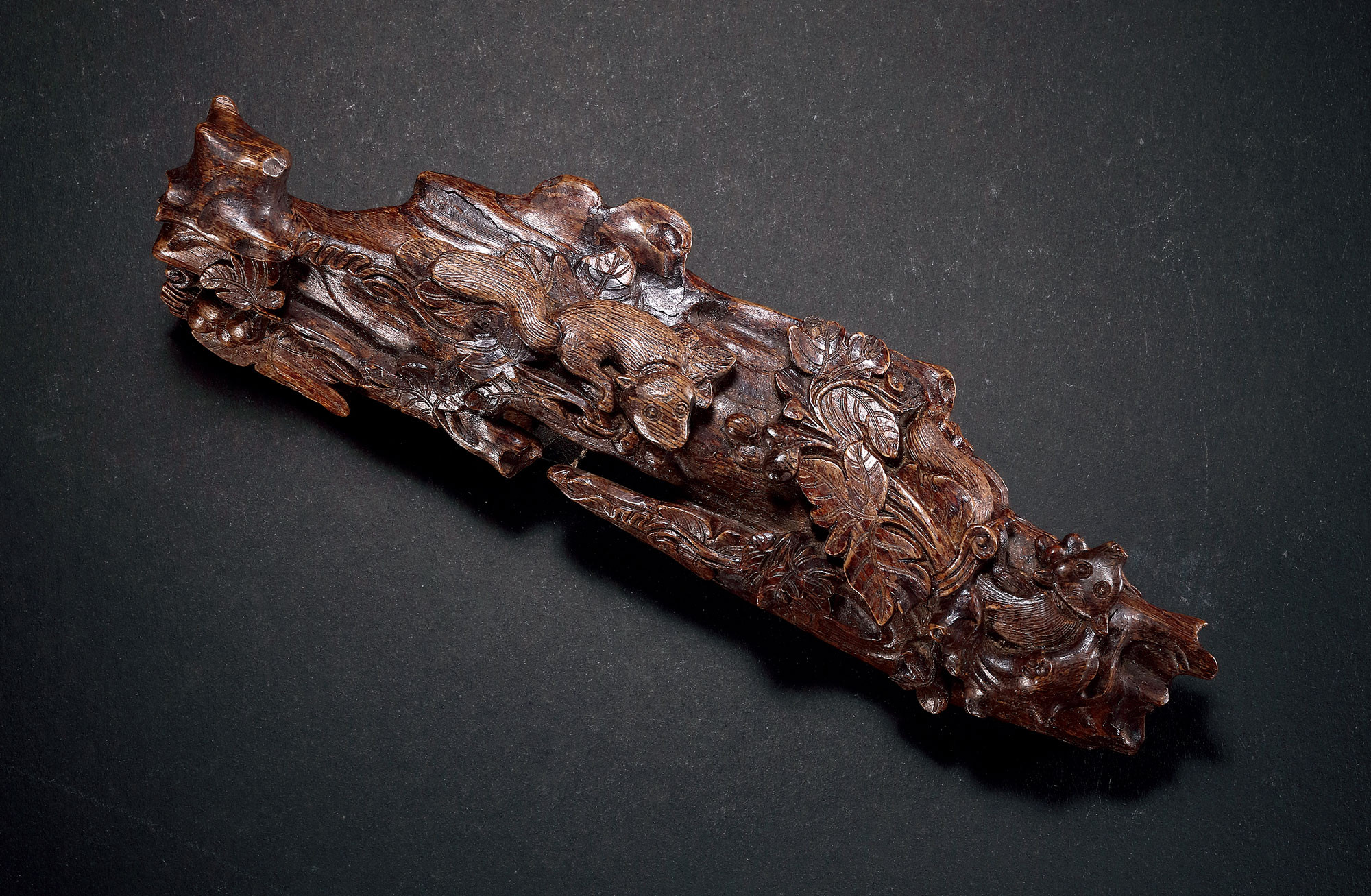 A AGILAWOOD CARVED ‘SQUIRREL AND GRAPES’ BRUSH STAND